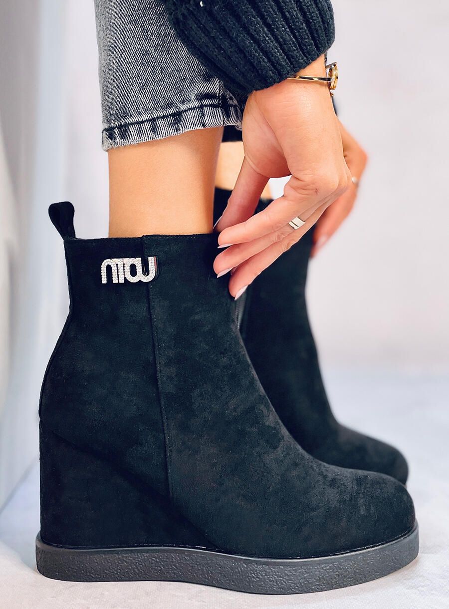 Black ankle boots on a wedge heel