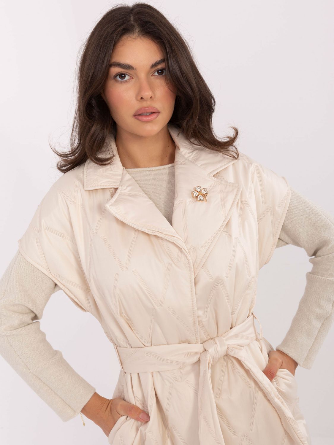 Elegant beige quilted vest with belt and brooch
